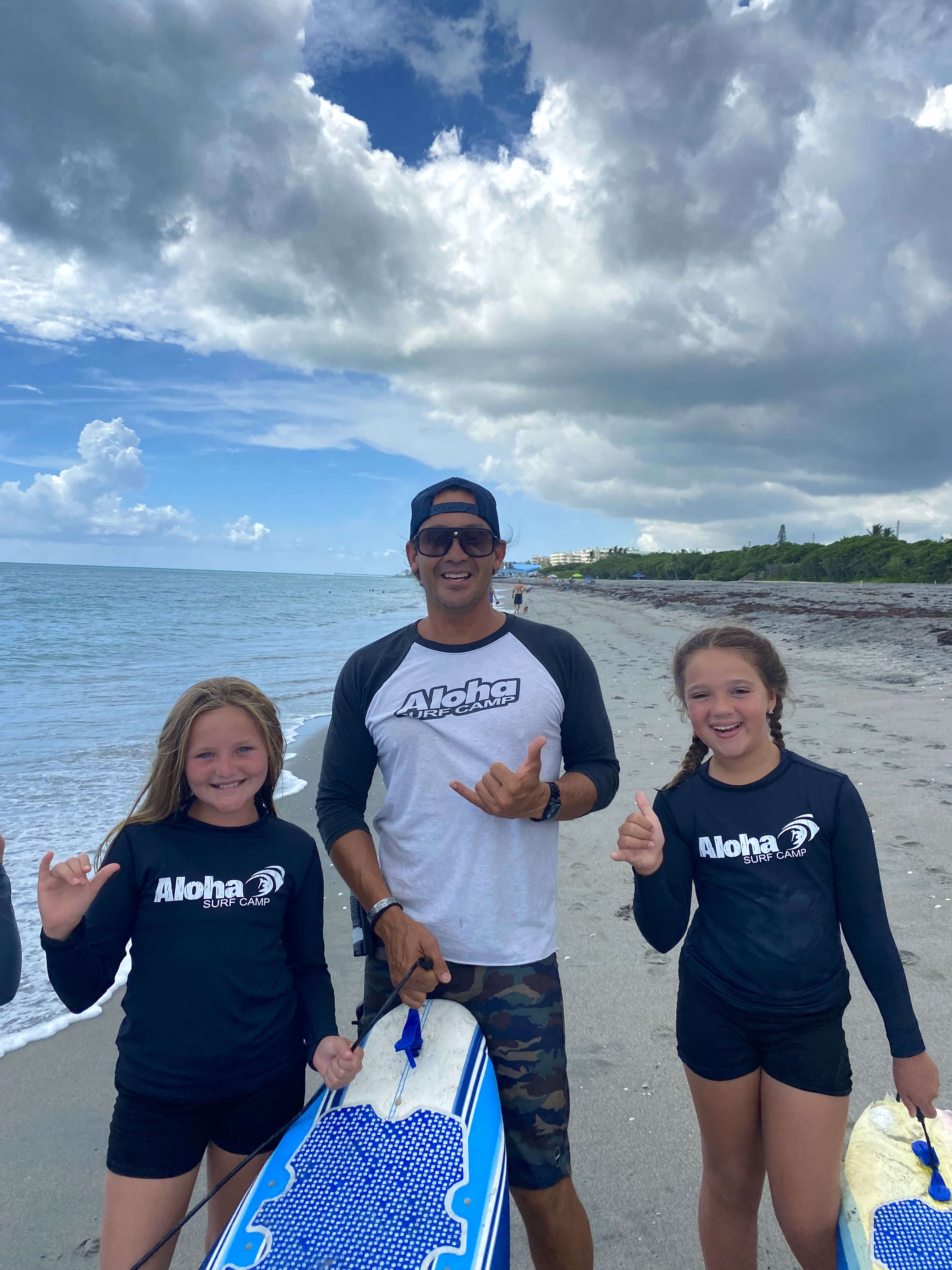 Coach Paul surrounded by happy campers on the beach