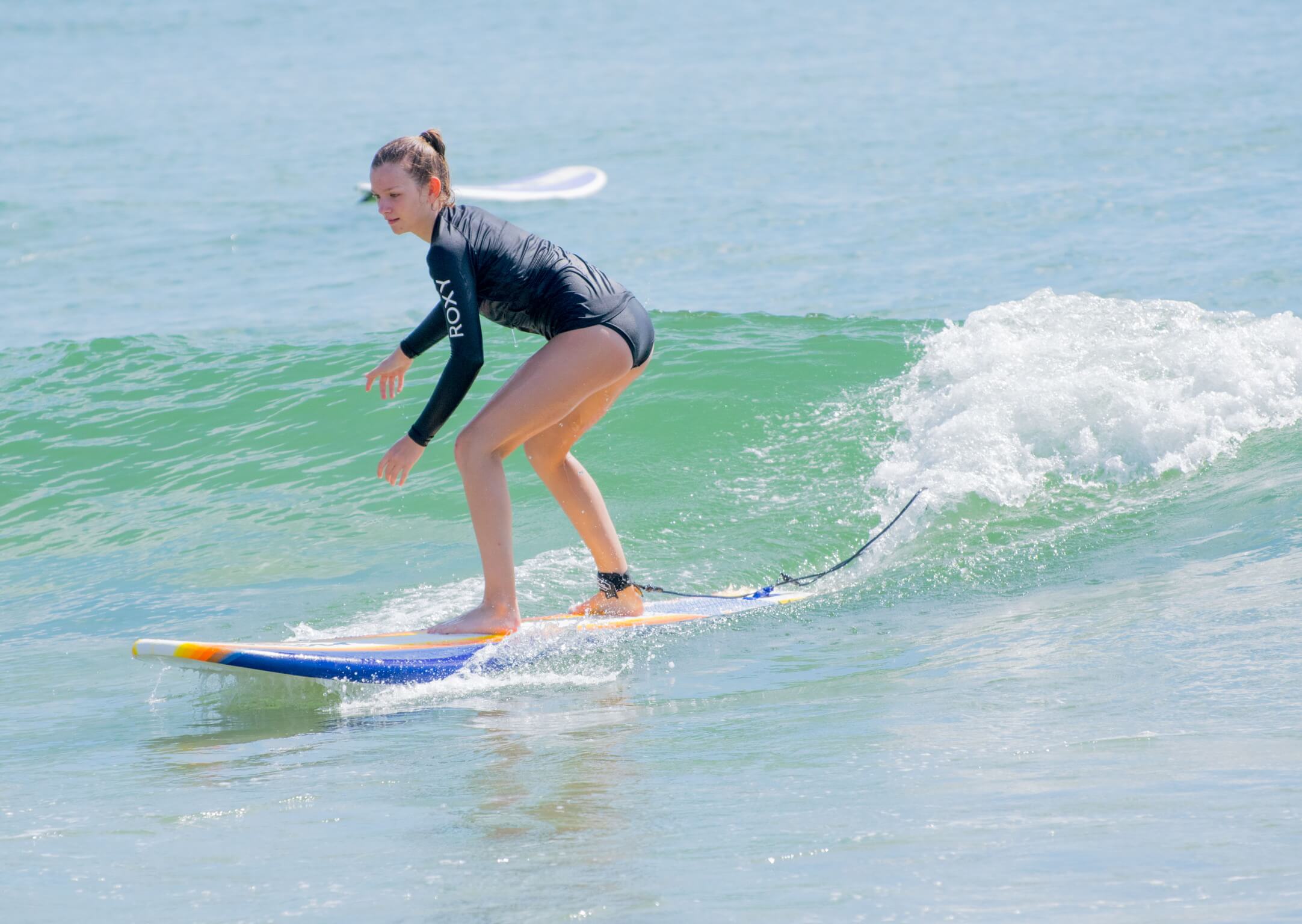 Teen girl surfing a wave with great form