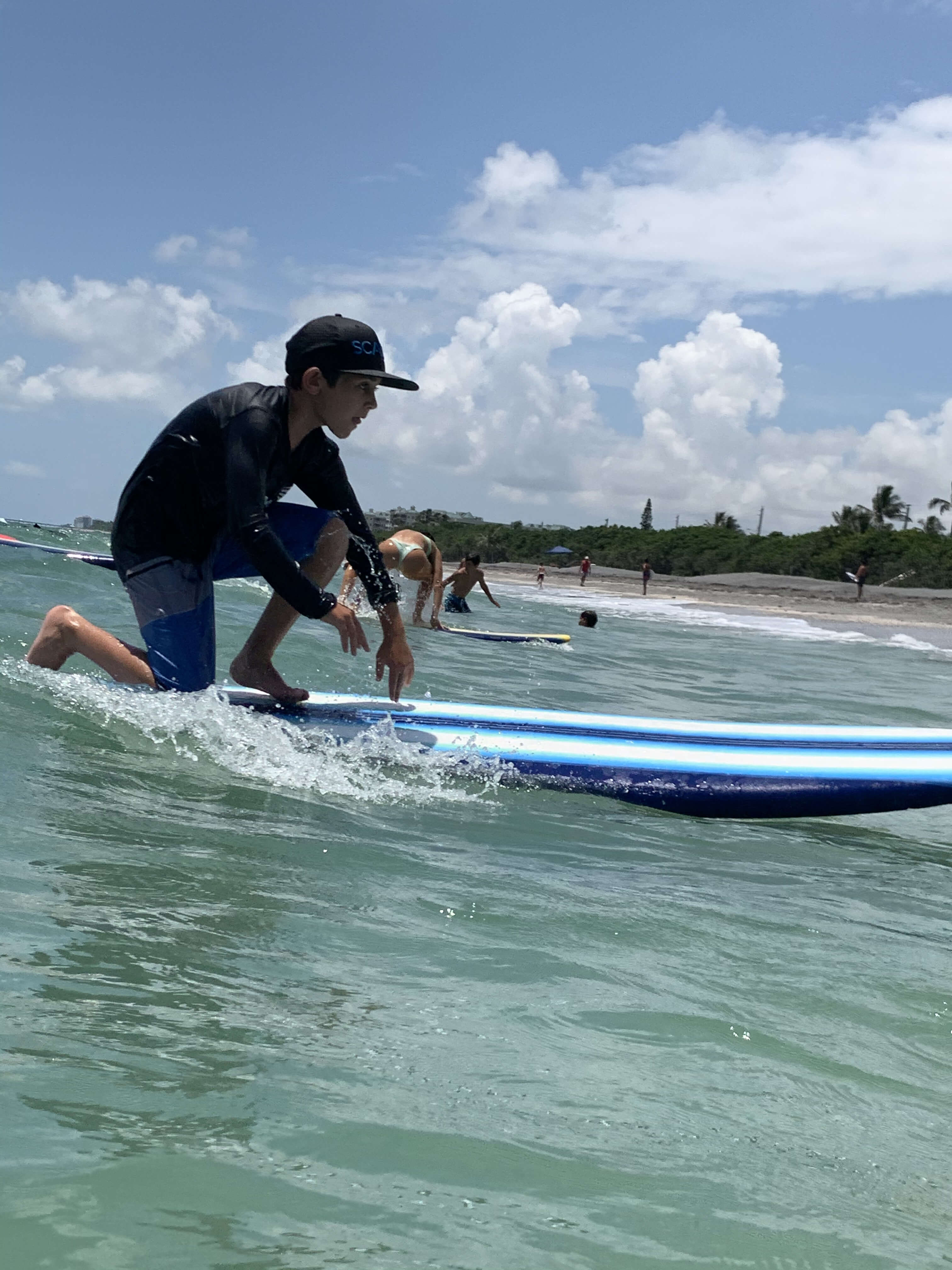 Young boy standing up on his first wave