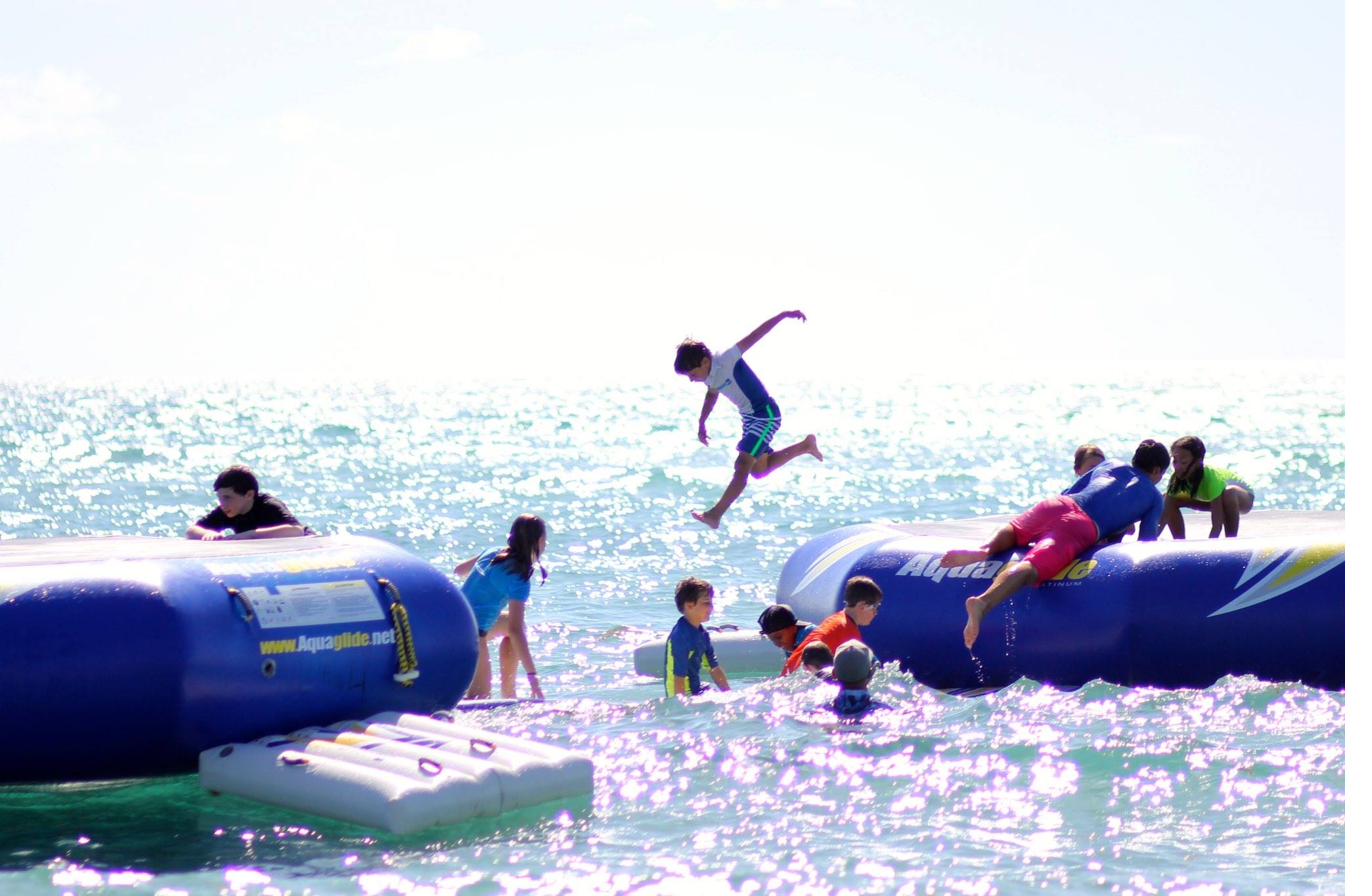Kid jumping off the water trampoline at Aloha Surf Camp